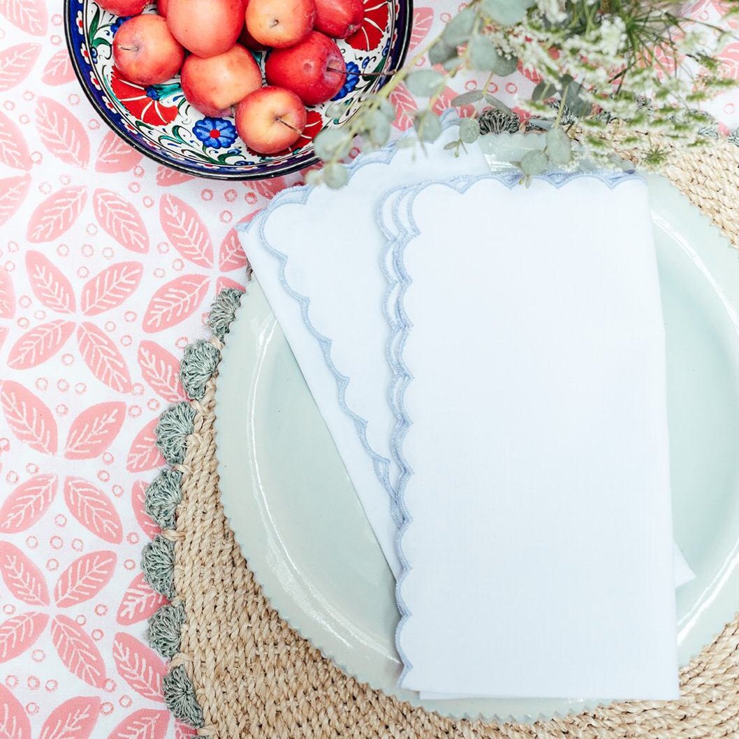 White napkin with blue scallop embroidered edge