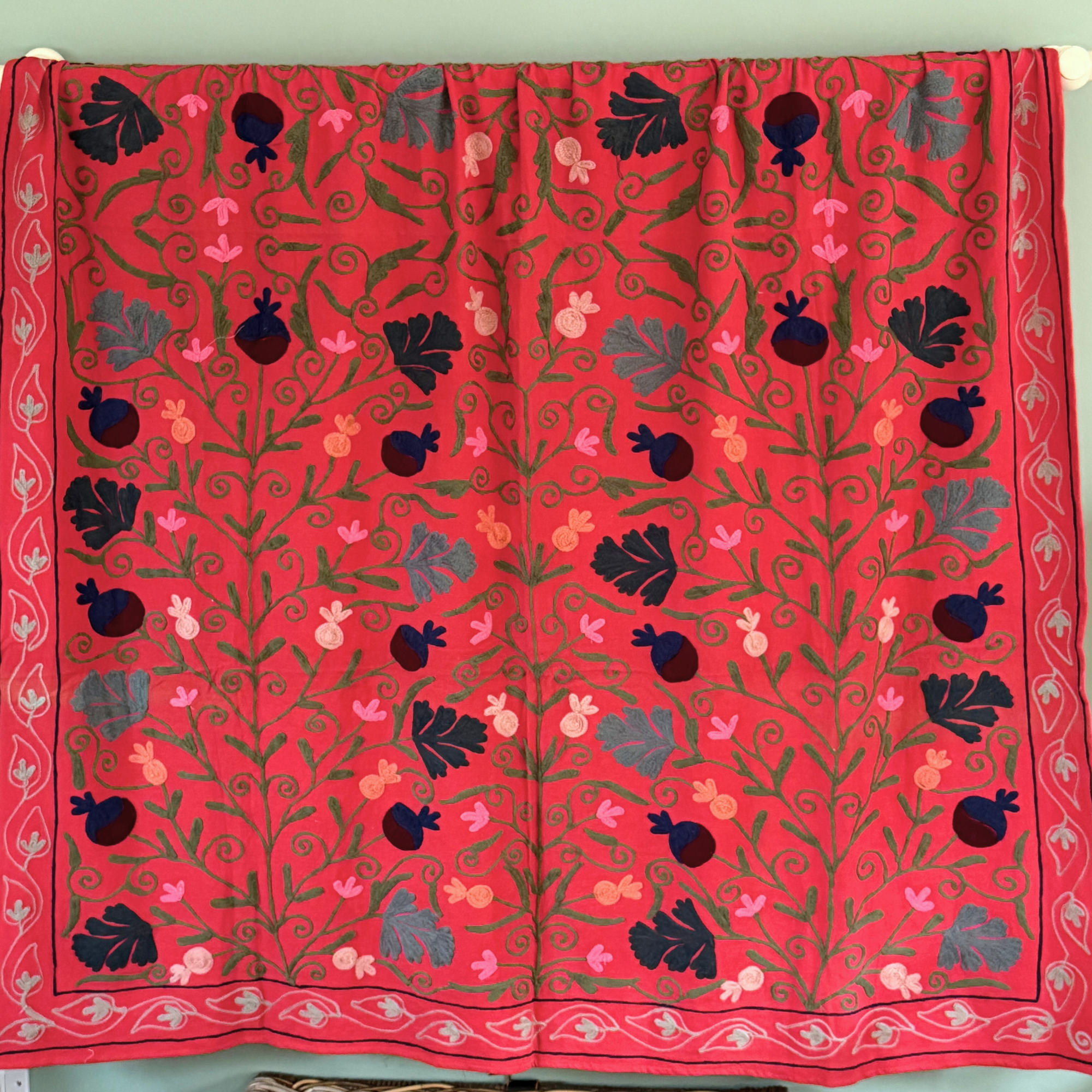 A unique, one-off hand embroidered floral cotton Suzani textile in red, blue, pink, coral