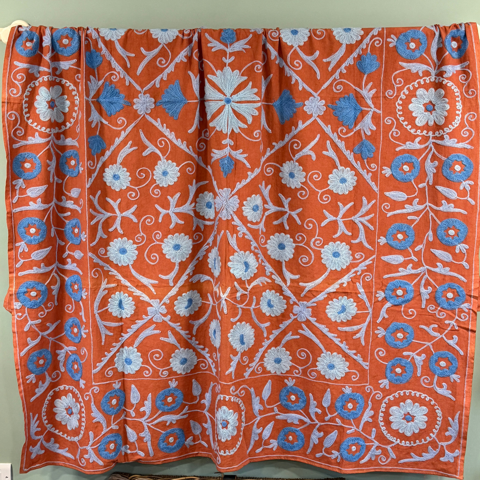 A unique, one-off hand embroidered cotton floral Suzani textile in red, orange, navy blue, pale blue
